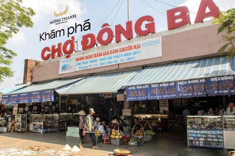 Một chiếc xích lô truyền thống và người đi bộ di chuyển gần cổng vào Chợ Đông Ba Huế, thể hiện phương tiện giao thông đặc trưng